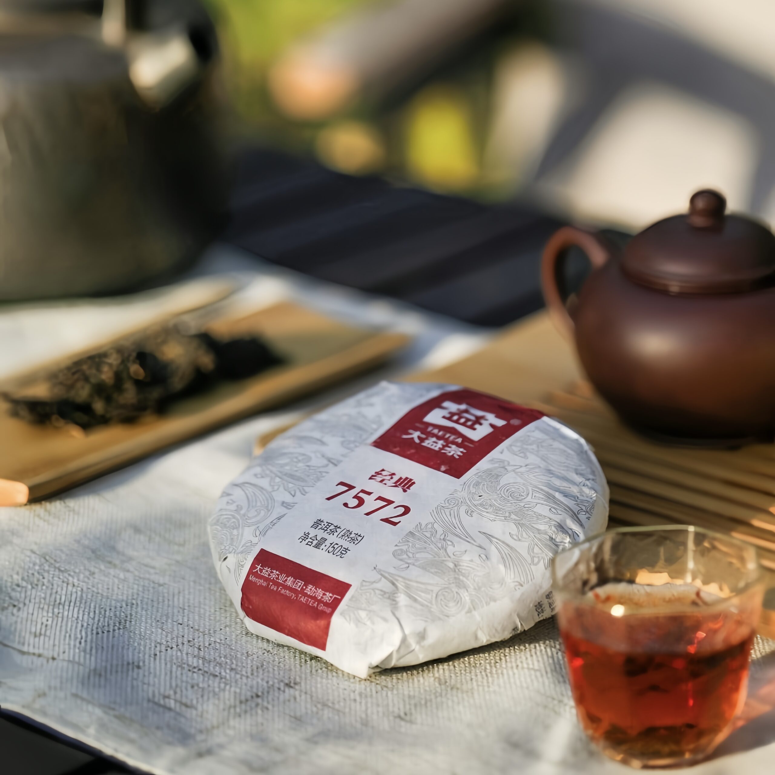 TRÀ PHỔ NHĨ 7572 VÂN NAM-150g Bánh trà Phổ Nhĩ 7572 gói giấy TAETEA 150g bên ấm tử sa và khay tre