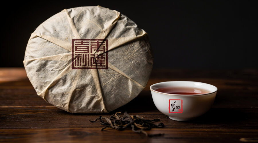 Giải Mã Mã Số Phổ Nhĩ: 7542, 7572 Nghĩa Là Gì Và Vì Sao Bánh Trà Nặng 357g? Bánh trà phổ nhĩ 357g gói giấy in mã số đặt trên bàn gỗ cùng chén trà