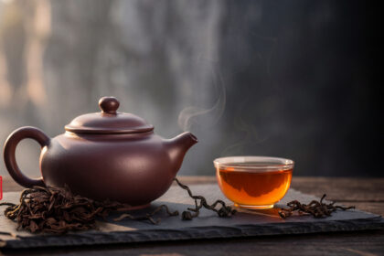 Trà Nhục Quế Vũ Di Là Gì? Giải Mã "Nham Vận" Và Câu "Hương Bất Quá Nhục Quế" Ấm tử sa và chén trà nhục quế Vũ Di nước hổ phách trên nền đá – ảnh đại diện bài viết