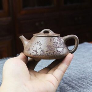 Ấm tử sa Vương An Phong nung củi, cầm trên tay