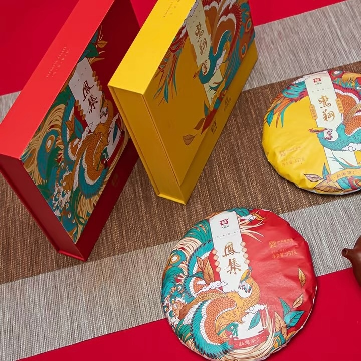 HỘP QUÀ PHỔ NHĨ ĐẠI ÍCH LOAN TƯỜNG - PHƯỢNG TẬP Hai bánh trà Loan Tường, Phượng Tập cùng hộp quà trên bàn trà