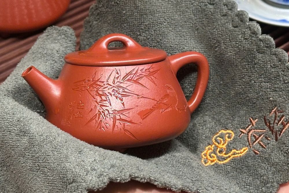 Cách dùng ấm tử sa đúng — lau bề mặt ấm bằng khăn sạch khi còn nóng